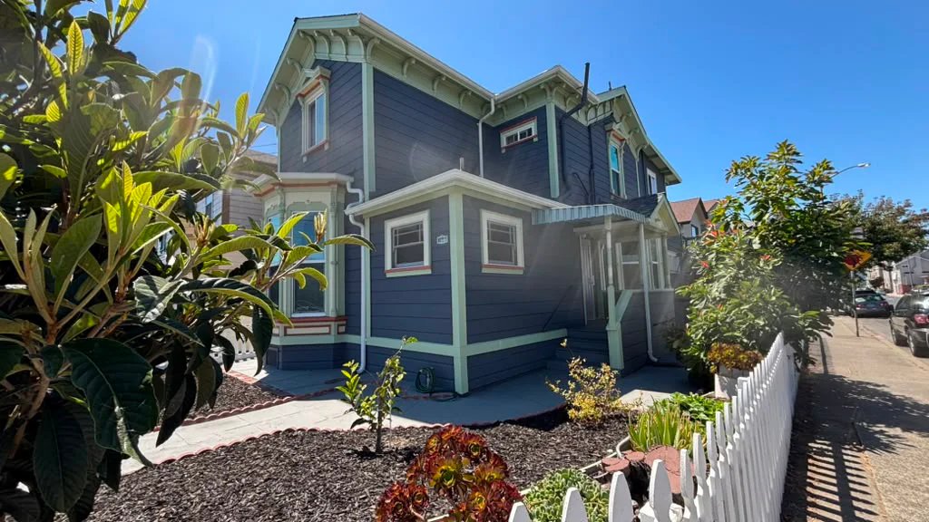 Blue two-story home with a landscaped front yard