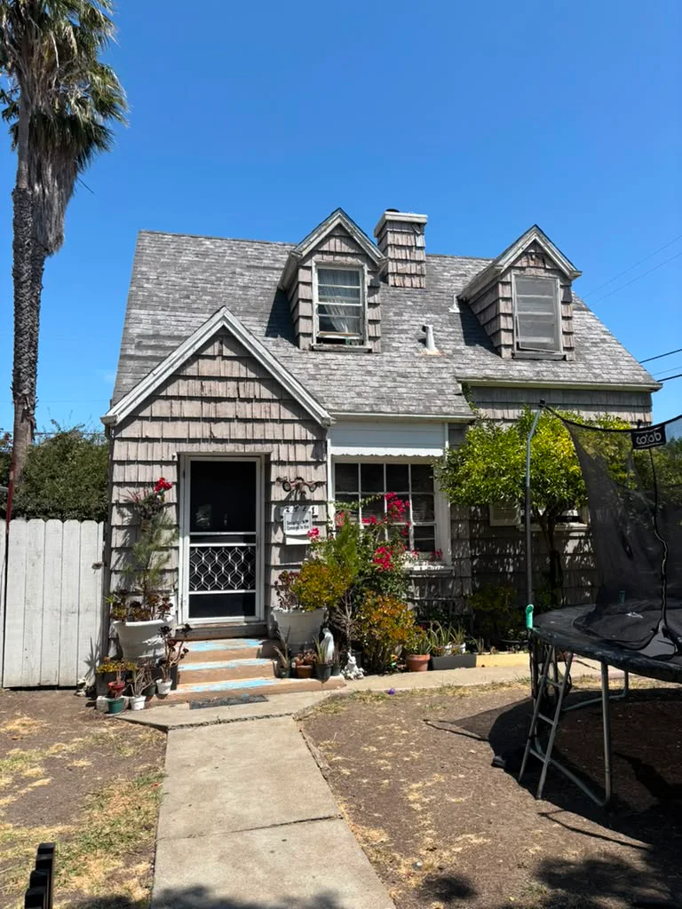 Older shingle-sided house with deferred exterior maintenance